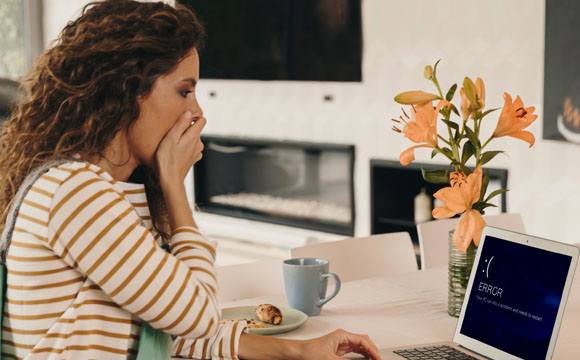 chica sorprendida mirando mensaje error en ordenador