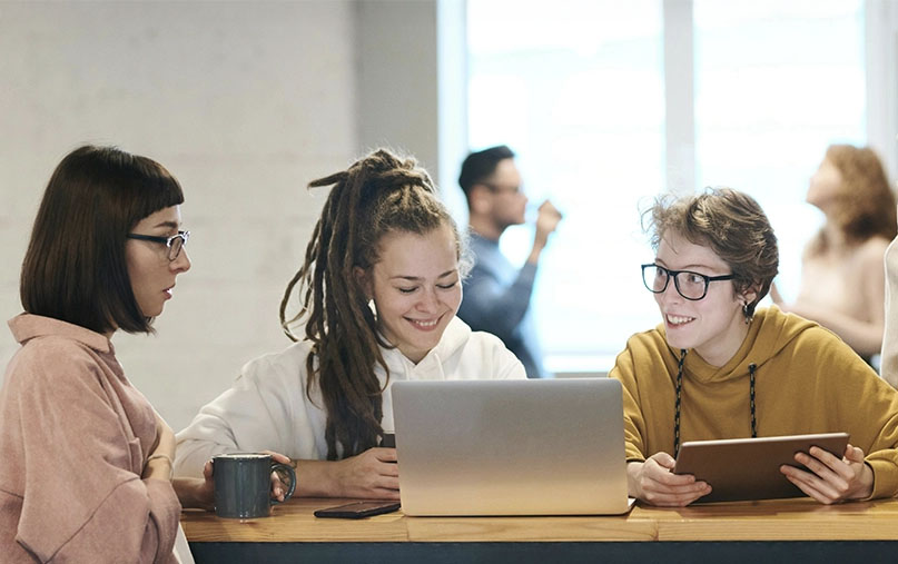 jóvenes modernos sonrientes con ordenador