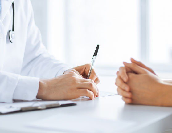 Médico haciendo un diagnostico a otra persona en una consulta