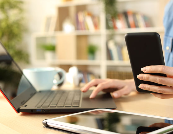 Persona utilizando un smartphone y un ordenador a la vez